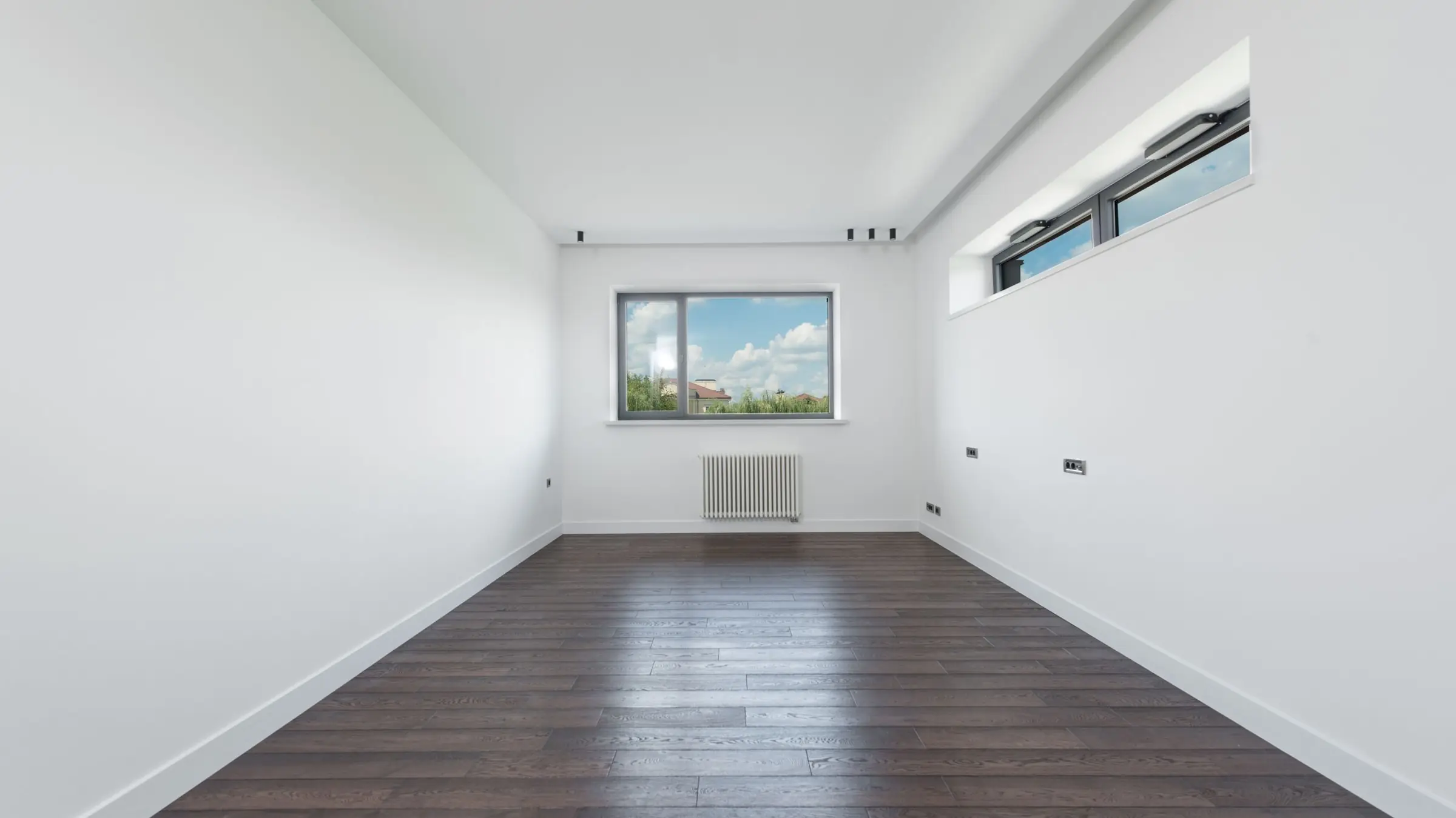 Habitación vacía de un piso con parquet, preparada para alquilar