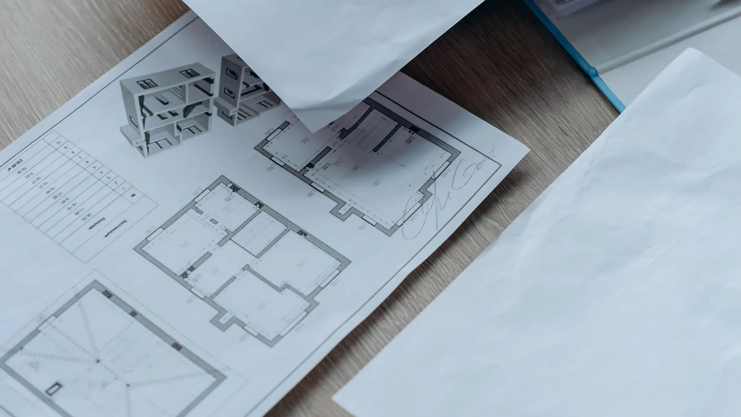 Planos de una vivienda desplegados sobre una mesa de madera